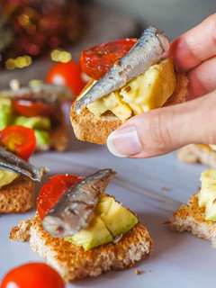 Una foto de Canapés de aguacate, cherrys y sardinillas