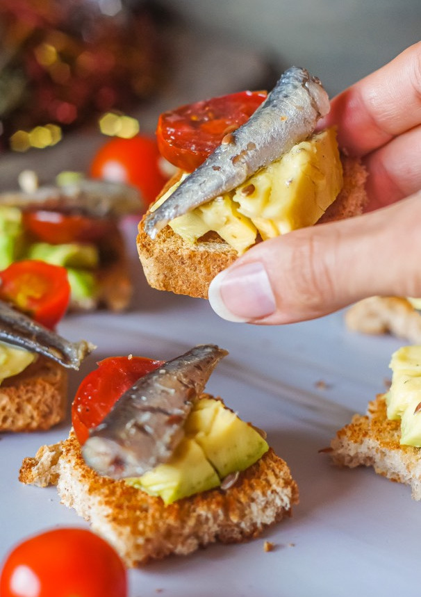Una foto de Canapés de aguacate, cherrys y sardinillas