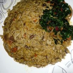 Palm Oil Rice and Beans Jellof Garnished with vegetable A picture of Palm Oil Rice and Beans Jellof Garnished with vegetable.