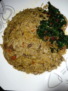 A picture of Palm Oil Rice and Beans Jellof Garnished with vegetable.