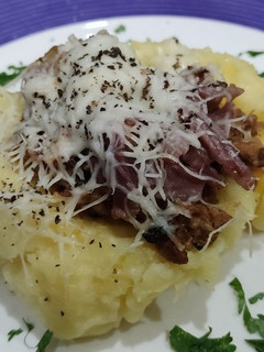 Una foto de Papa rellena con carne molida y lomo embuchado, gratinada con queso