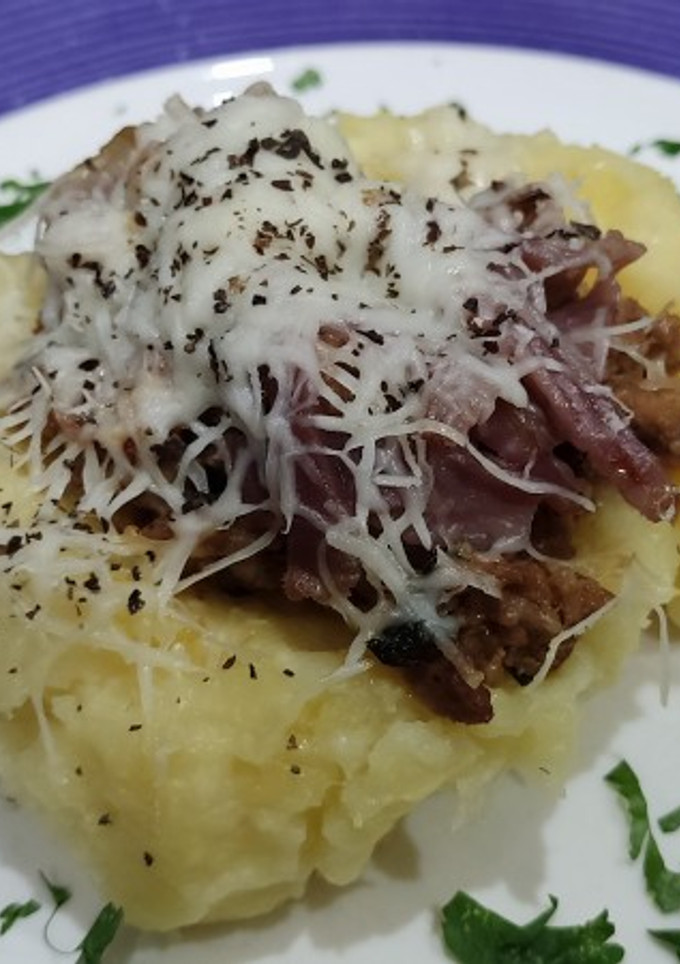 Una foto de Papa rellena con carne molida y lomo embuchado, gratinada con queso