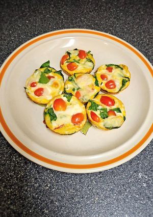 A picture of Egg Cups With Tomato, Swiss, and Spinach.