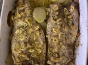 Una foto de lubina al horno con ajo y perejil