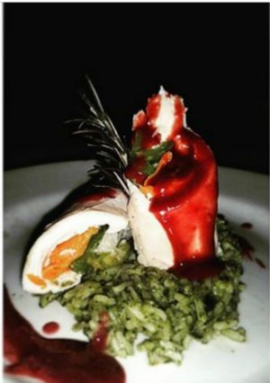 Una foto de Pechuga de pollo rellena, arroz de espinaca y salsa de vinotinto