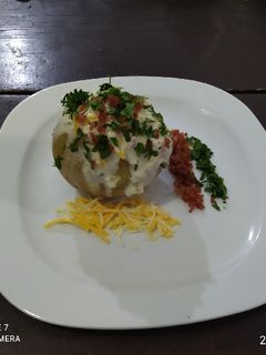 Una foto de Papa horneada con tocino y crema