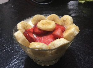 Una foto de Postre de queso gouda y cremoso, banana y frutillas