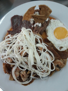 Una foto de Chilaquiles con camarones y salsa de chile habanero