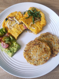Una foto de Omelette relleno, hashbrown y crema de aguacate