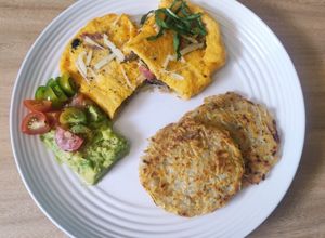 Una foto de Omelette relleno, hashbrown y crema de aguacate