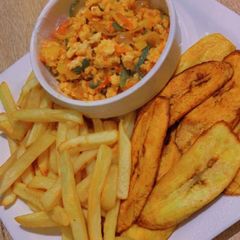 A picture of Chips,plantains and egg sauce.