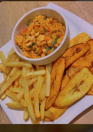 A picture of Chips,plantains and egg sauce.