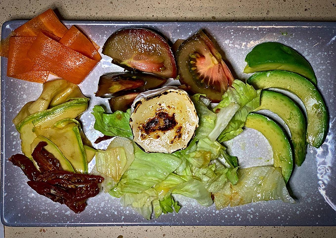 Ensalada de tomates, aguacate, verduras encurtidas y rulo de cabra tostado