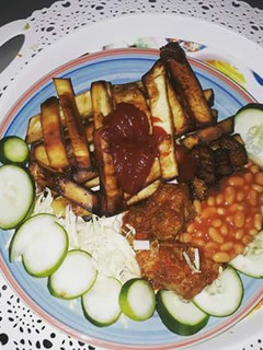 A picture of Fried sweet potatoes with cabbage,cucumber and baked beans.