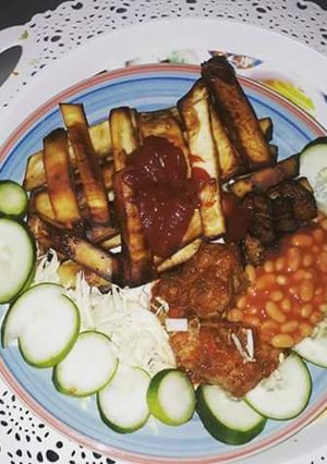 A picture of Fried sweet potatoes with cabbage,cucumber and baked beans.