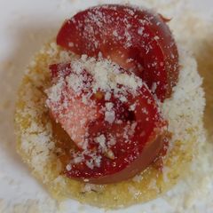 A picture of Polenta topped with Parmesan and tomato.