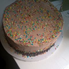 A picture of Pinacolada cake covered in chocolate whipped cream.