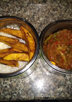 A picture of Rice, plantain and snail sauce.