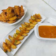 A picture of Crispy potato wedges with spicy mango sauce.