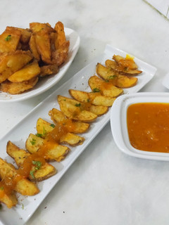A picture of Crispy potato wedges with spicy mango sauce.