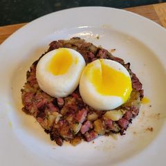 A picture of Corned Beef Hash w/ Poached Eggs.