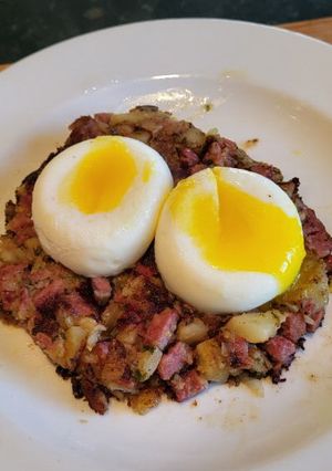 A picture of Corned Beef Hash w/ Poached Eggs.