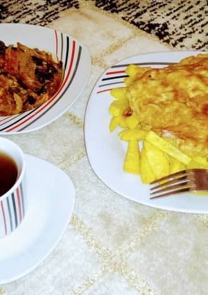 A picture of Smooked fish pp with chips and egg and black tea.