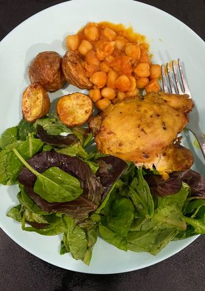 Una foto de Pollo con papas al horno, y garbanzos en pasta de tomate