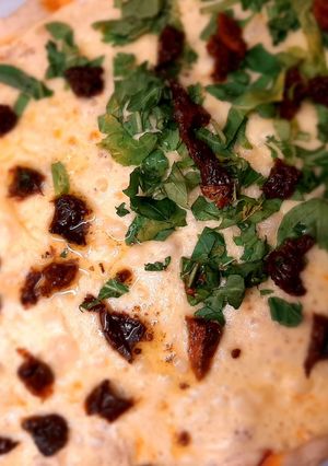 Una foto de Pizza muzzarella con rúcula y tomates secos