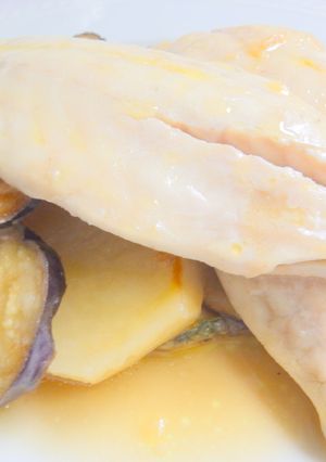 Una foto de Lubina al horno con patatas calabacín y berenjena