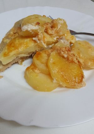 A picture of Meat with potatoes in the oven.