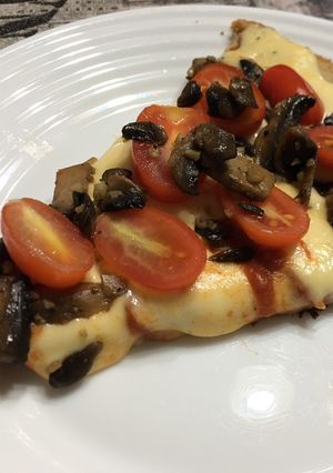 Una foto de Pizza de masa de avena con tomates cherry y hongos salteados con ajo