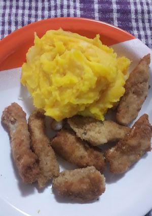 Una foto de Bastoncitos de filete de merluza con puré de papas y zapallo