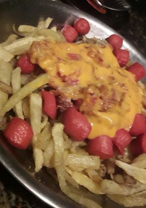 Una foto de Papas fritas con cheddar panceta y salchichas