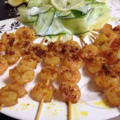 A picture of Shrimp Tikka with cucumber ribbon salad.