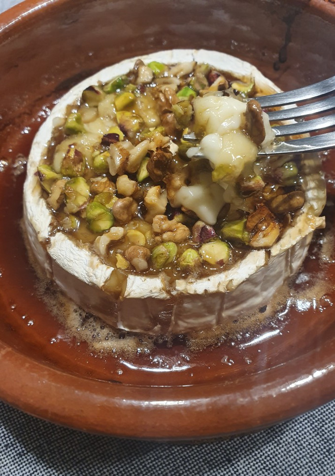 Una foto de Queso camembert fundido con miel, pistachos y nueces