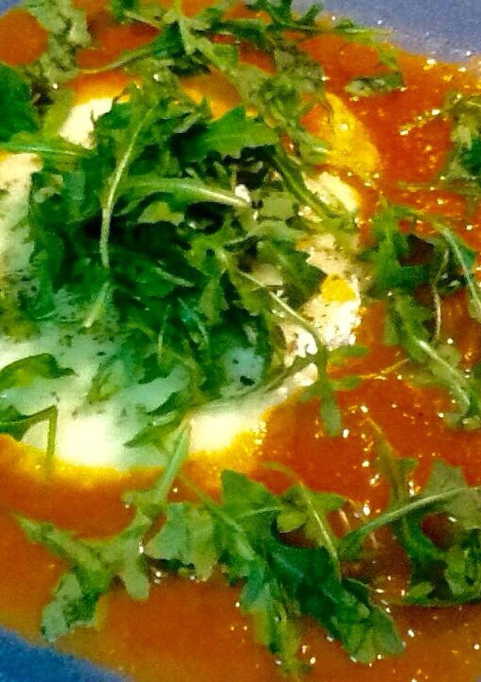 Una foto de Queso provolone con salsa de tomate y rúcula 