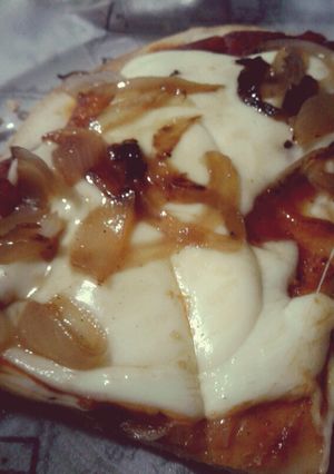 Una foto de Pizza casera con cebolla caramelizada