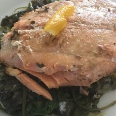 A picture of Salmon over cooked greens.
