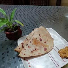 A picture of Aloo parantha with achar.