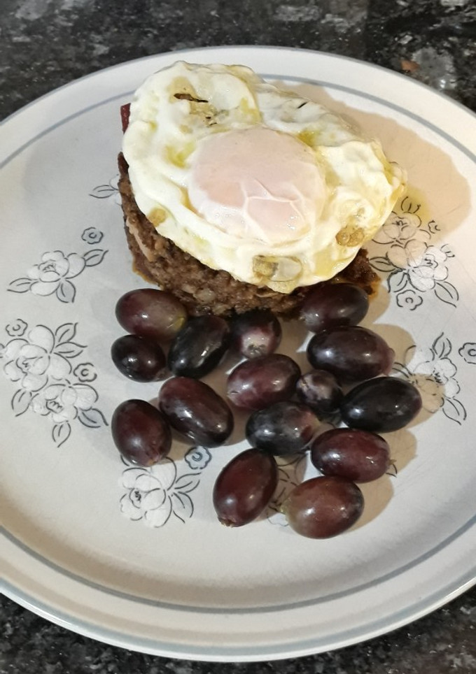 Una foto de Migas bávaras, con chorizo, panceta, huevo frito y uvas negras