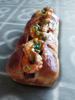 Una foto de Brioche de panceta ibérica, piquillos y gambas