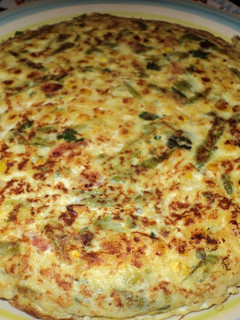 Una foto de Tortilla de porotos verdes, choclo y tomate a la albahaca