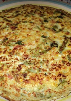 Una foto de Tortilla de porotos verdes, choclo y tomate a la albahaca