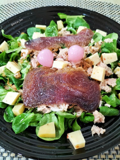 Una foto de Ensalada de canónigos con atún, mojama y queso de tomates secos con aceitunas negras