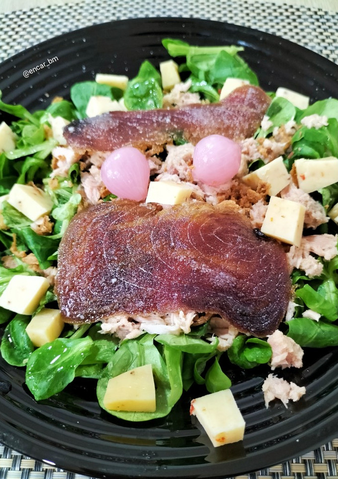 Una foto de Ensalada de canónigos con atún, mojama y queso de tomates secos con aceitunas negras