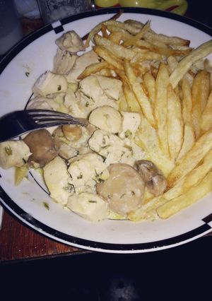 Una foto de Pollo al champignón con papas fritas