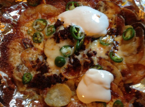 Una foto de Nachos hechos con papa, chorizo y tocino