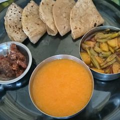A picture of Tasty Unique Healthy Phulka Roti with Potato Cluster Bean Sabji and Mango Juice with Mango Pickle.