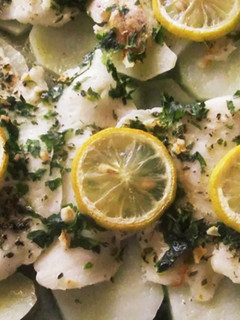 Una foto de Merluza sobre patatas al limón